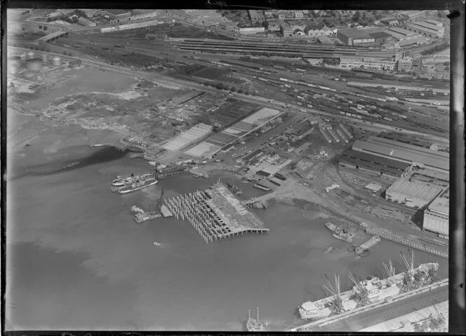 Cargo ships, stacked timber and car ferry, wharf for exports, Auckland