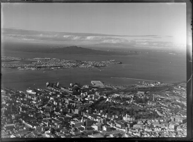 Auckland City and wharves, showing Devonport and Rangitoto Island in the distance