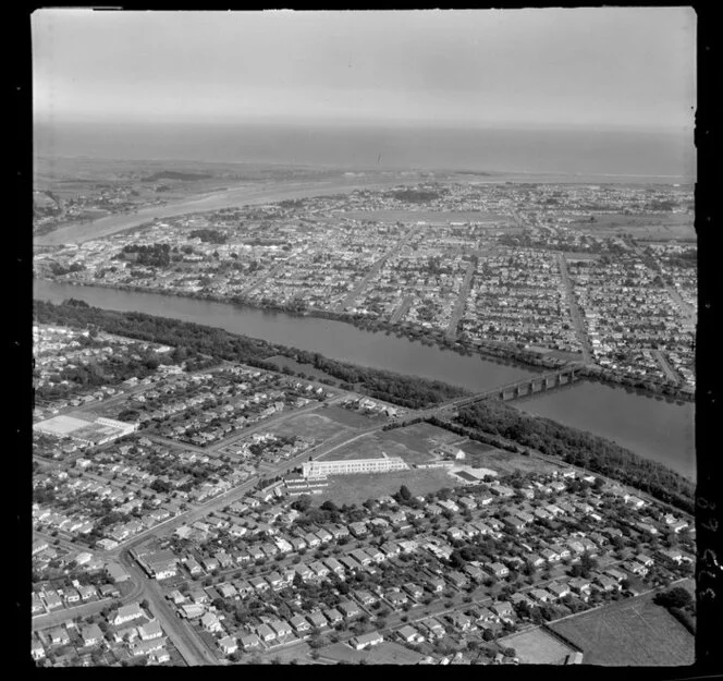 View over Wanganui Girls College, Wanganui East, with Jones Street and Middle Bridge, Anzac Parade and Dublin Street, to the Wanganui River Mouth and coast beyond