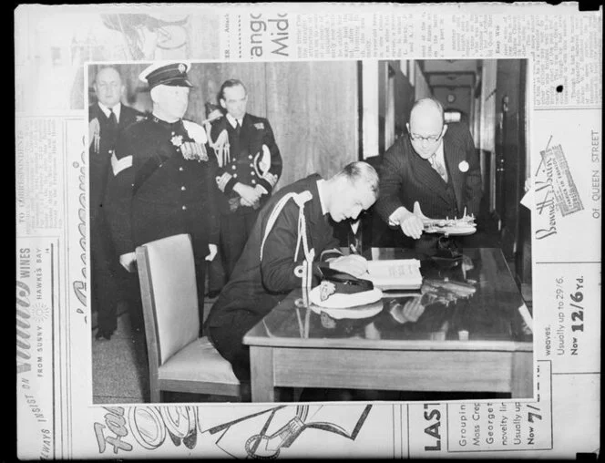 'Whites copy, christening of Aotearoa' according to envelope, image shows Duke of Edinburgh signing a book, with model of a seaplane