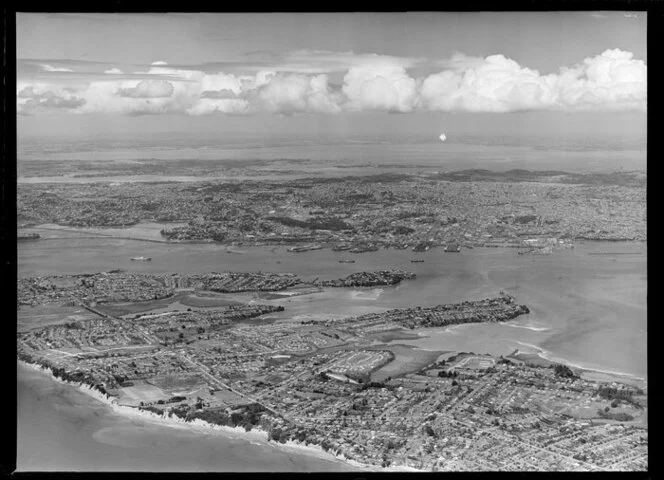 North Shore (foreground), Auckland wharves and harbour (centre) and Manukau Harbour in the distance
