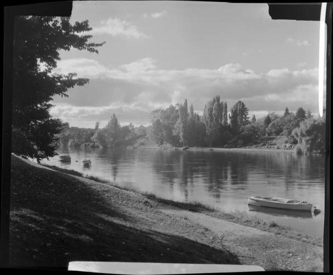 Waikato River in autumn, Hamilton, with small boats moored along the shoreline