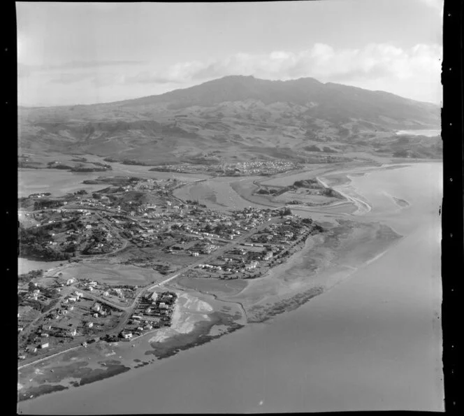 Raglan, Waikato, view along the coast with Wallis Street and wharf and tidal estuary, Wainui Stream with bridges, farmland and Mt Karioi beyond