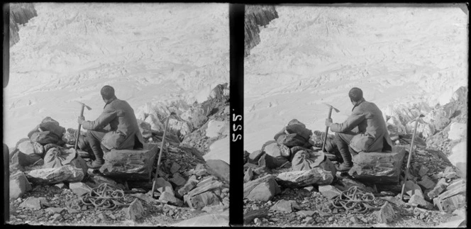 Climber, sitting in the snow, surrounded by climbing gear, [Westland National Park?]