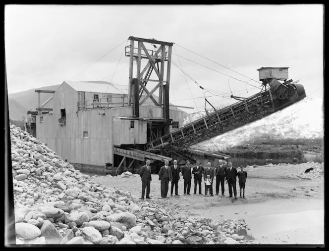 Group of directors and boy in front of the Argo dredge