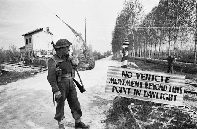 Kaye, George, 1914- : D M Prendergast of the 21 NZ Battalion alongside a sign in the Senio River region