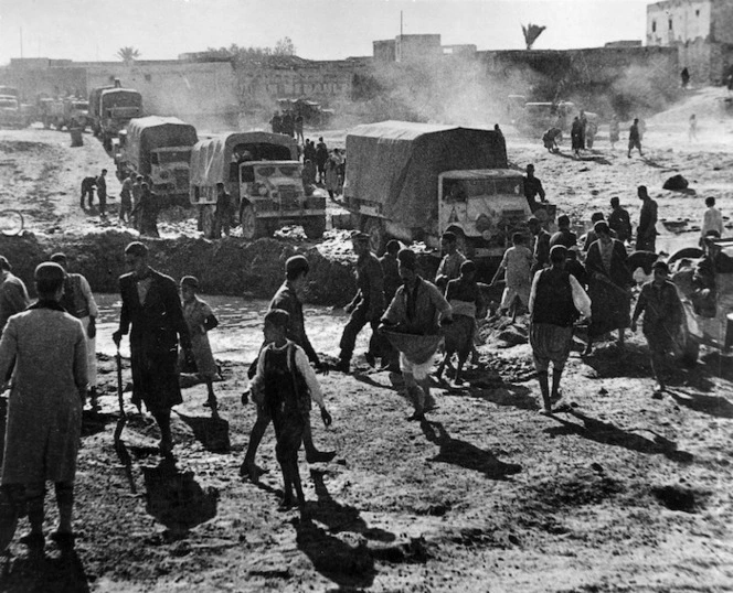 New Zealand convoy passing through Gabes while the local population repair a canal crossing