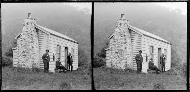 Men outside a wooden cottage during a rabbit hunting expedition, Murdering Beach, Otago