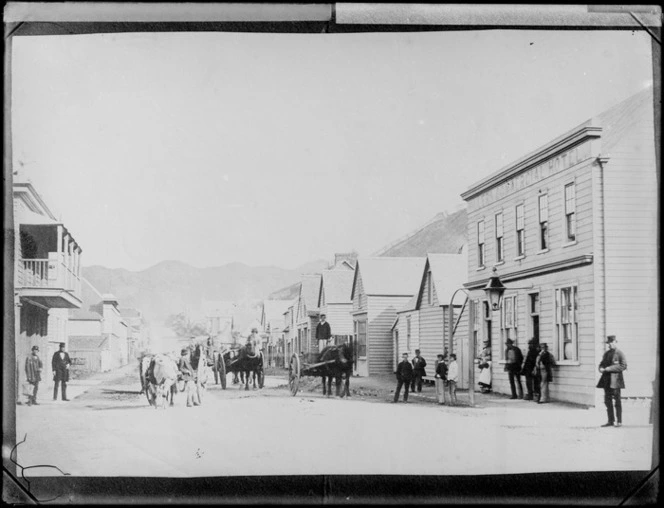 Looking south west along Willis Street, Wellington, towards Brooklyn, showing Millers Commercial Hotel, left, Empire Hotel, right, and horse-drawn carts in street