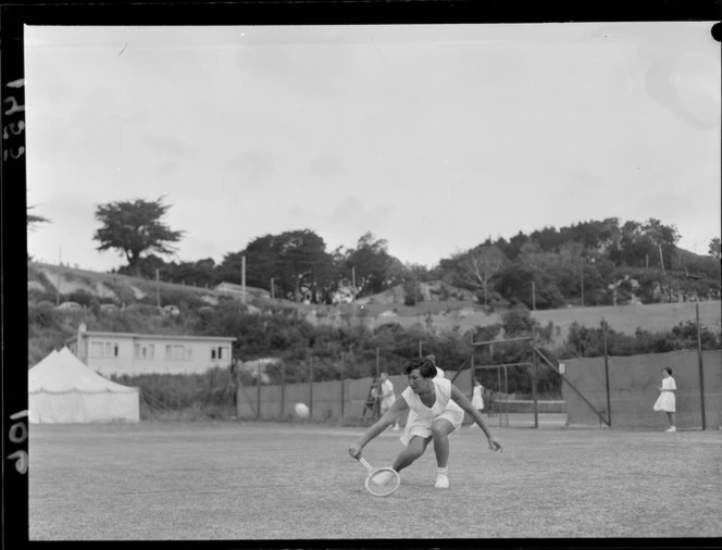 Unidentified woman competing on a grass court in a national tennis tournament, location unidentified
