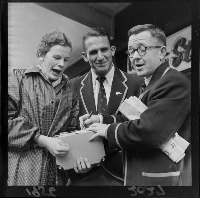 Two unidentified members of the 1956 Springbok rugby union football team sign autographs