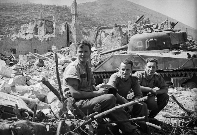 Members of the 4 NZ Armoured Brigade alongside a Sherman tank, after the capture of Cassino, Italy - Photograph taken by George Kaye