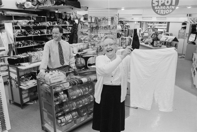 Shop assistant holding large bloomers, Carey's Drapery Store, Lower Hutt, Wellington - Photograph taken by Ross Giblin
