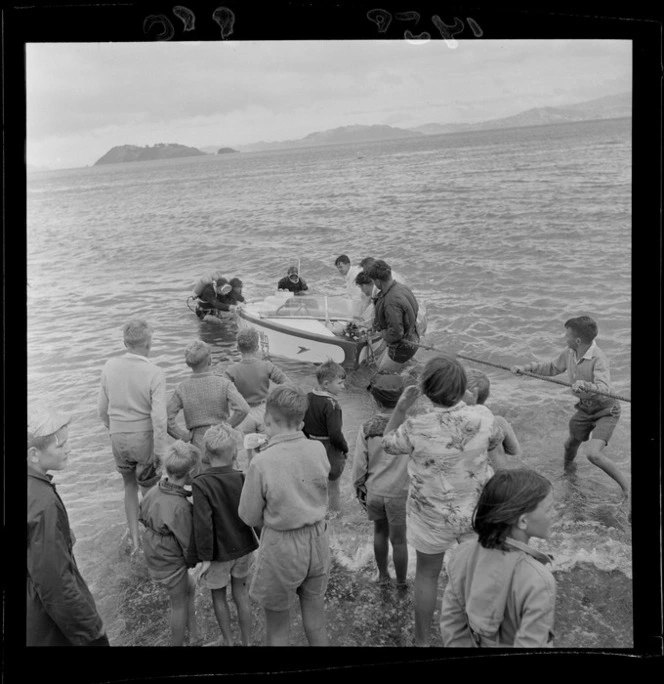 Boat being pulled onto the beach watched by a group of children, speedboat regatta, Petone