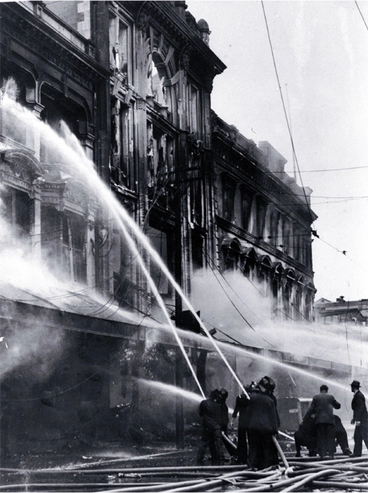 Image: Firemen dampening down the main entrance of Ballantyne's, Colombo Street, Christchurch
