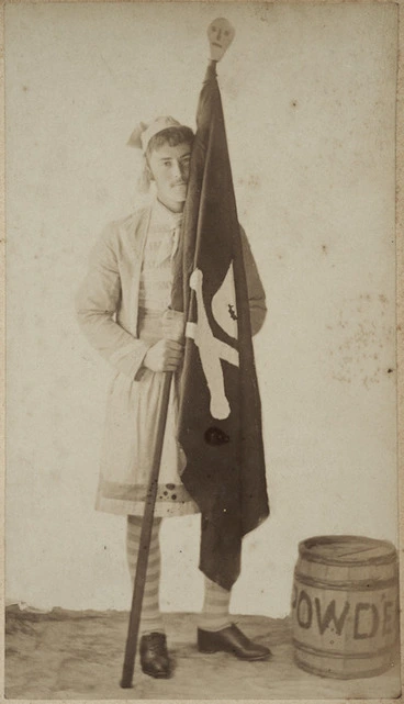 Image: Young man dressed as a pirate holding a black flag