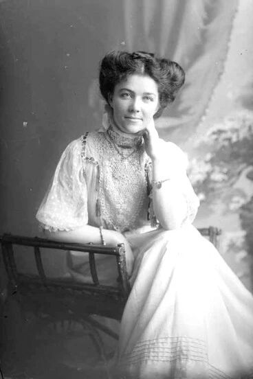 Image: 3/4 portrait of Miss Nolan seated, leaning her left elbow on....