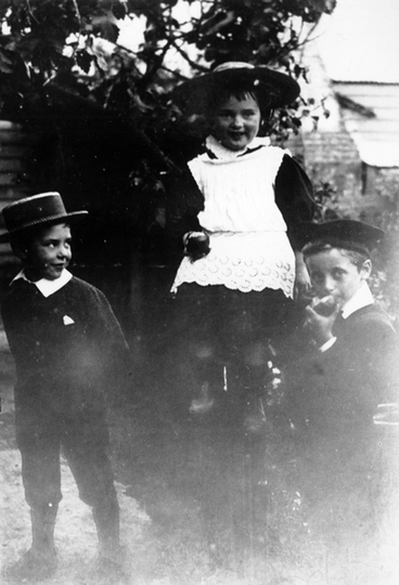 Image: Three children eating apples in the garden