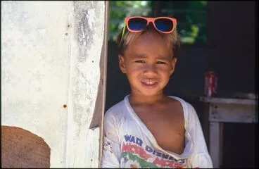 Image: Child wearing pink framed sunglasses