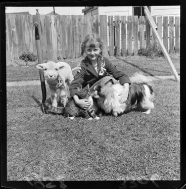 Image: Leslie Morrison, who wears her hair in plaits, with her pet lamb, cat, and dog