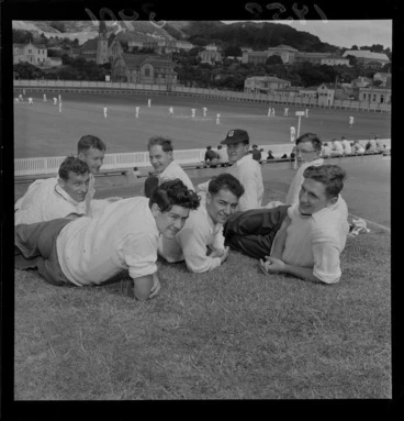 Image: Unidentified cricket players on embankment, with game of cricket being played in background, Basin Reserve, Wellington