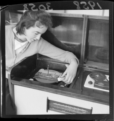 Image: Unidentified woman placing a greeting card on a turntable to demonstrate that it can also be used as a record