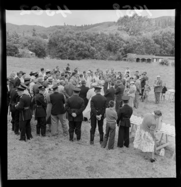 Image: Crowd at the opening of the Stokes Valley water supply, Lower Hutt, Wellington Region, including men in uniform and trestle tables with cups and urns of water