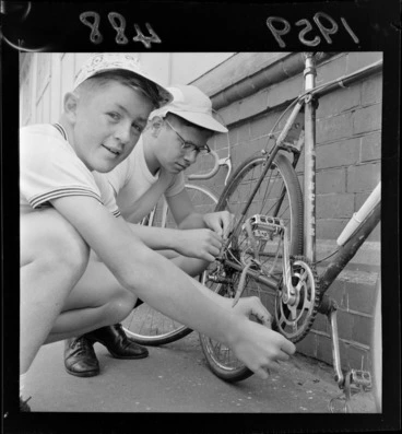 Image: Two unidentified boys fixing the chain on a bicycle after taking part in a schoolboy's cycle race