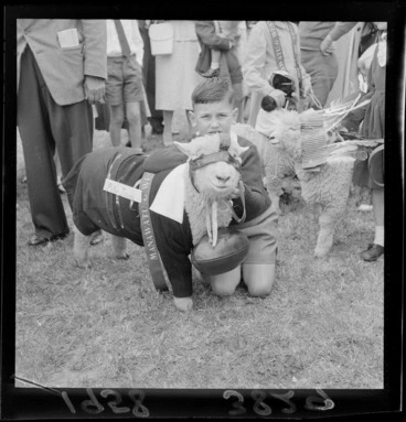Image: Unidentified young boy with his winning pet lamb, which is dressed as a rugby player including jersey, shorts, ball, and headgear, Palmerston North Agricultural & Pastoral Show (A & P Show), Manawatu-Whanganui Region