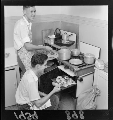 Image: Two unidentified young men baking and cooking at the home for University students