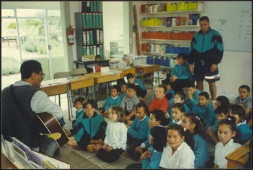 Image: Principal playing guitar and singing with class
