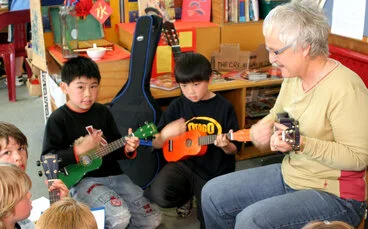 Image: Teacher and children with ukeleles
