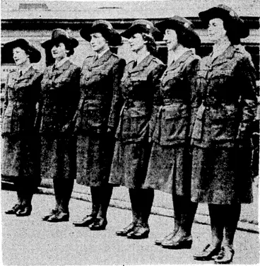 Image: Evening I Post" Photo.. Tlie uniform which is being worn by the Women's War Auxiliary. Coat and skirt are greenish khaki in colour, and tlieir felt hats are turned up at the side and pinned with a Neiv Zealand badge. (Evening Post, 02 September 1941)