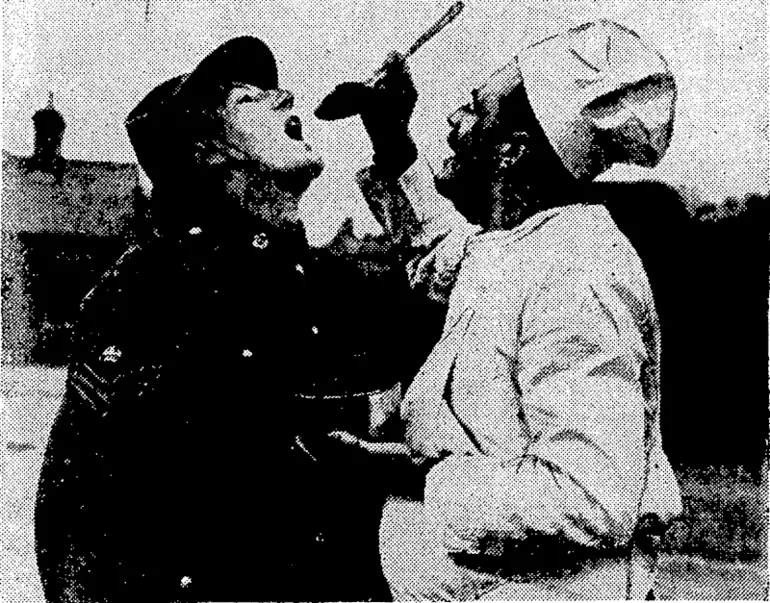 Image: Sport and General" Photo. A Canadian army cook from Peterborough, Ontario, whose name is Cooke, giving a taste* of Christmas pudding to Staff-Sergeant-Major Hollis, of the New Zealand Army Service Corps. , (Evening Post, 25 January 1941)