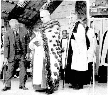 Image: Ivon .1. Hill Photo. Archbishop Averill wearing the mat presented to him by the Maoris ai the official opening of the new meeting-house at Whangara last Wednesday. The Archbishop conducted the religious portion .of the ceremony. Sir Apirana Ngata (left) supervised the programme and translated the speeches for the benefit of European visitors (Evening Post, 17 April 1939)