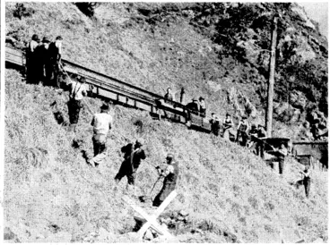 Image: Evening Post" Photo. A further stage in the duplication of the : Wellington-Paekakariki section of the North Island Main, Trunk Railway. Heavy rails (weighing 85lb to the yard) for the double track being unloaded near No. 13 tunnel, between Plimmerton and Paekakariki. (Evening Post, 23 September 1939)