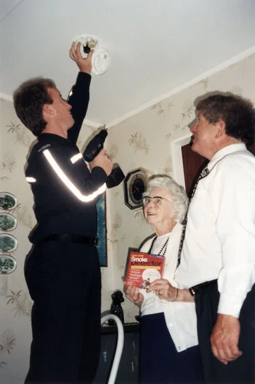 Image: Fire safety; smoke alarms for council housing; Fire Officer Brent Wilson, Mrs Peggy Weir, Mayor Rex Kirton.