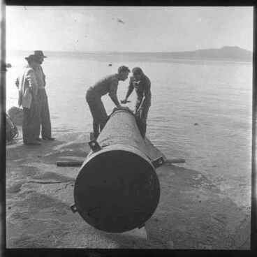 Image: Showing two men working on a a pipeline, with Rangitoto in the background