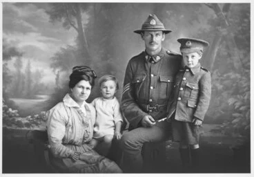 Image: 3/4 group portrait showing Sergeant Francis and family, boy on the right wears a child's military uniform and his father's 4th (Waikato) Mounted Rifles hat.