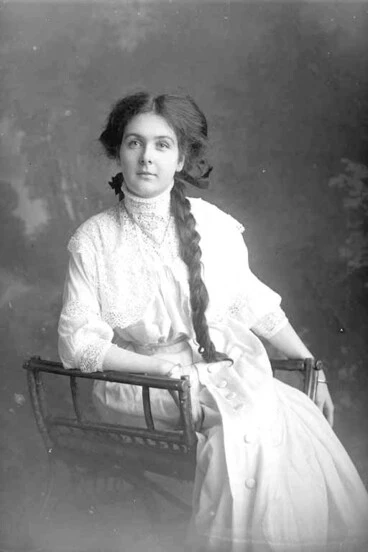 Image: 3/4 portrait of Miss Robinson seated, wearing a light coloured,....