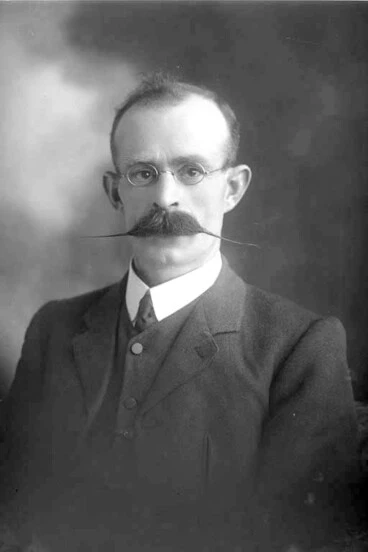 Image: 1/4 portrait of Mr Nicholls who has a wide waxed moustache and....