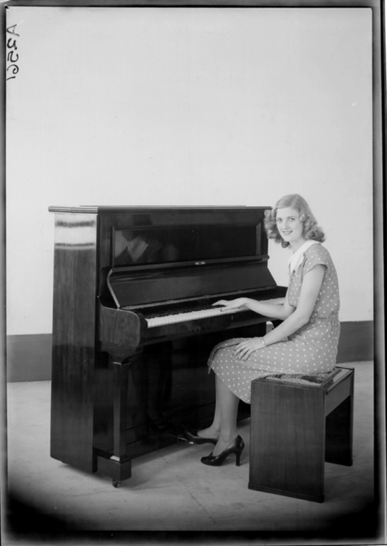 Image: Full length portrait of a model seated at a piano for Atwaters Limited 1940