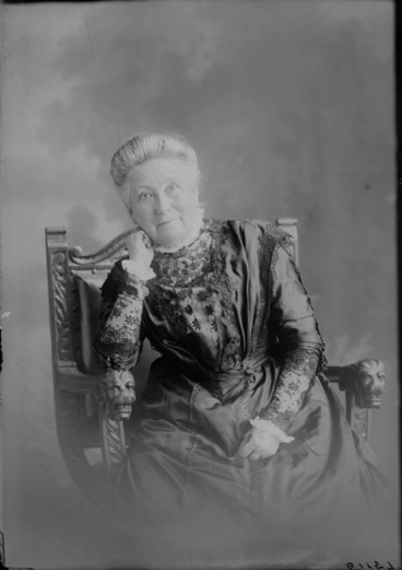 Image: 3/4 length portrait of Mrs Gittas seated in a carved wooden....