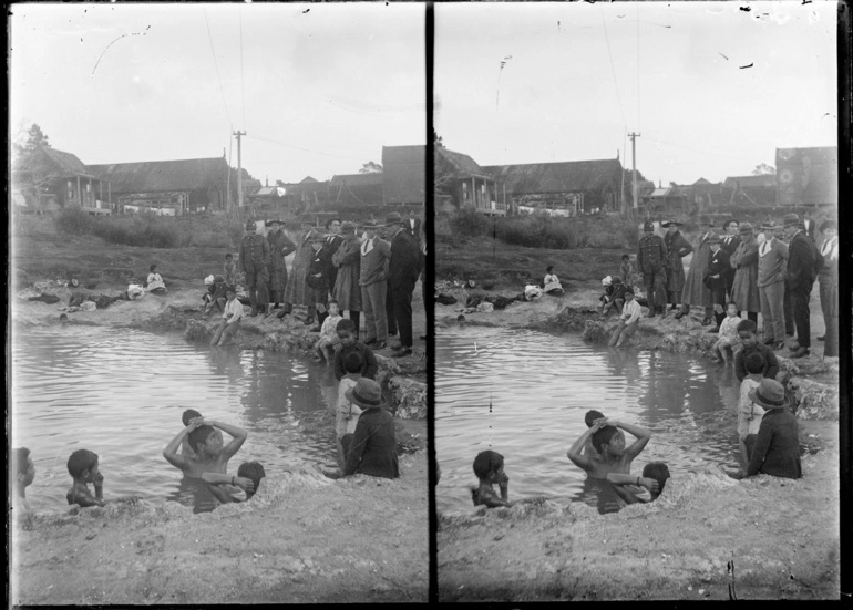 Image: Men, women and children gathered around a pond...