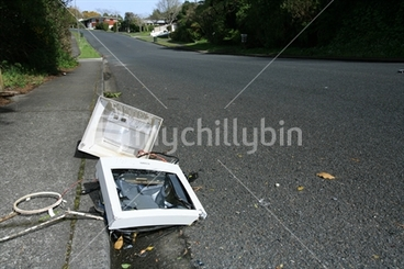Image: The remains of a computer screen smashed in a gutter in a suburban street
