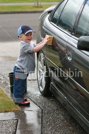 Image: 3 year old boy cleaning car