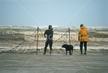 Image: Two men and their dog, dragging a net, Oreti Beach, Southland.