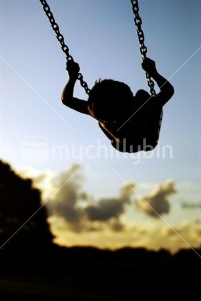 Image: A child swings up high with freedom