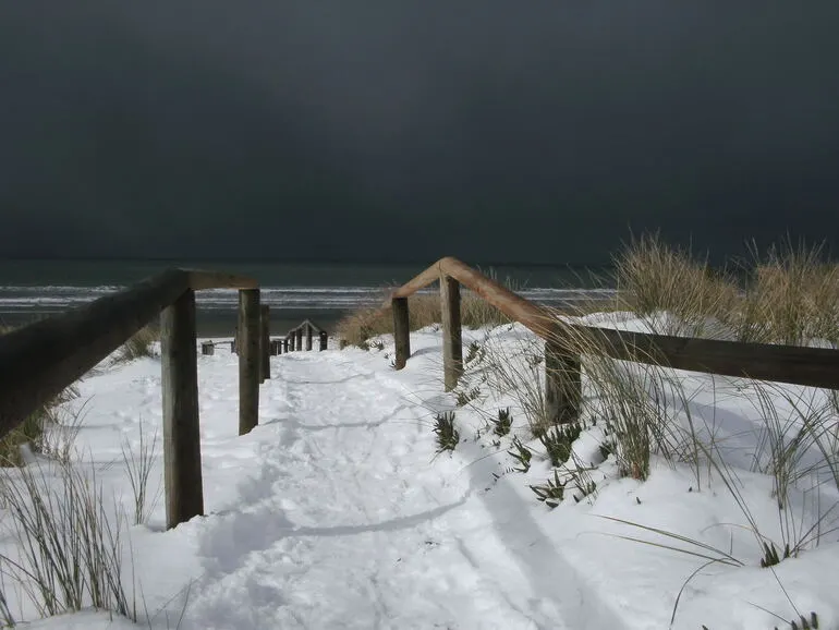Image: Snowy New Brighton Beach with dark stormy sky