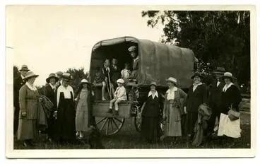 Image: Photograph, Black and White: Lovell-Smith family group standing beside a covered wagon.